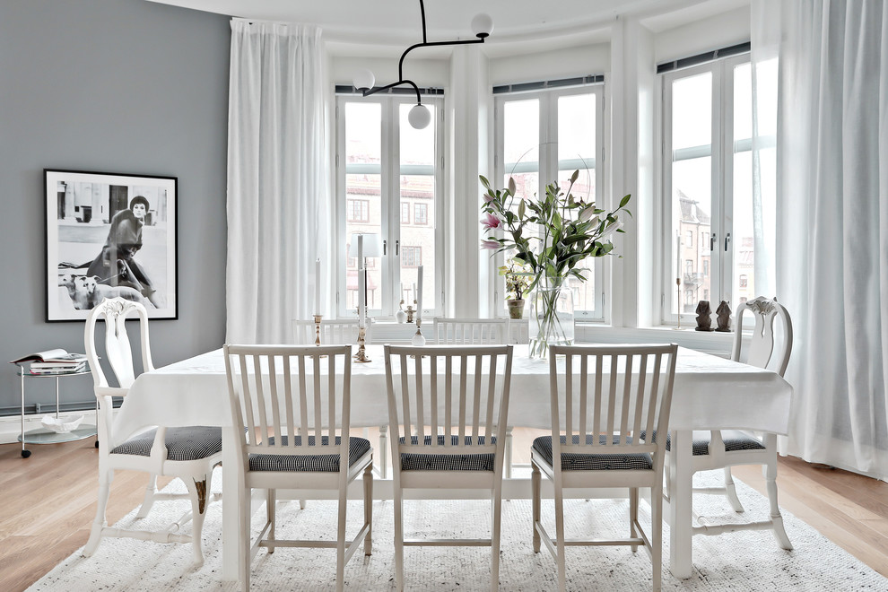 Photo of a scandinavian dining room in Gothenburg with grey walls, light hardwood floors and beige floor.