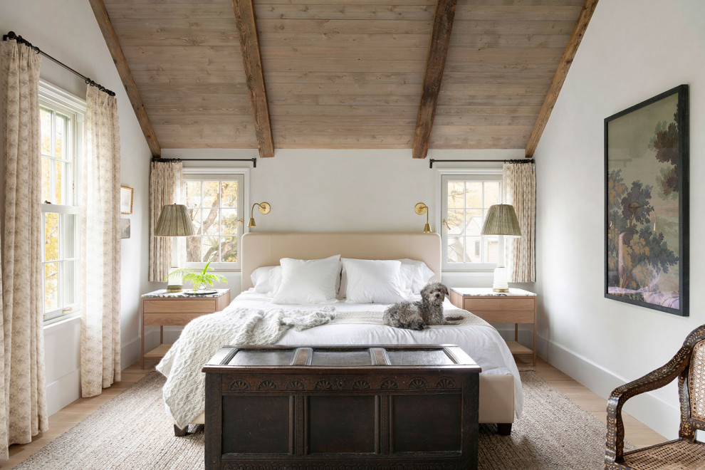 На фото: хозяйская спальня в стиле кантри с белыми стенами и балками на потолке с