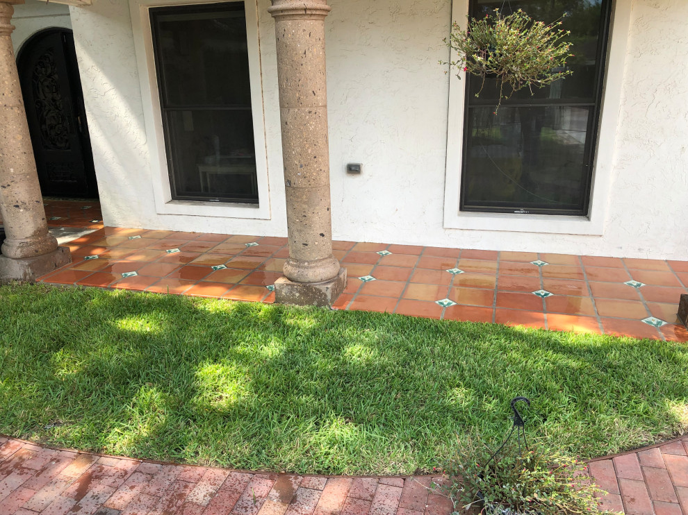 Design ideas for a mid-sized front yard verandah in Houston with tile.