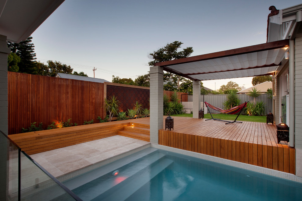 This is an example of a large contemporary backyard partial sun outdoor sport court in Perth with natural stone pavers.