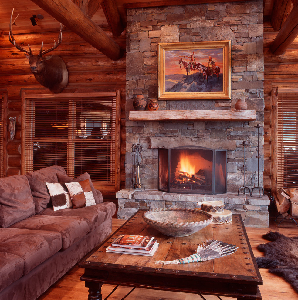 Photo of a mid-sized country open concept living room in Other with brown walls, medium hardwood floors, a standard fireplace and a stone fireplace surround.