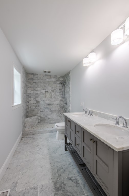 Large transitional master bathroom in Boston with shaker cabinets, grey cabinets, an open shower, a one-piece toilet, gray tile, white tile, subway tile, white walls, slate floors, an undermount sink and solid surface benchtops.