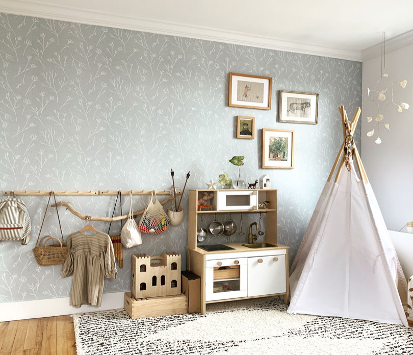 This is an example of a scandinavian kids' room for girls in New York with green walls and light hardwood floors.