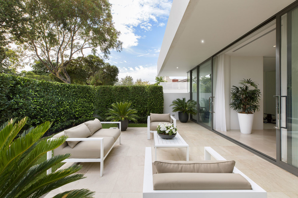 This is an example of a contemporary courtyard formal garden in Melbourne with natural stone pavers.