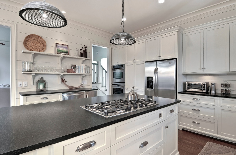 Inspiration for a mid-sized beach style u-shaped eat-in kitchen in Charleston with shaker cabinets, white cabinets, stainless steel appliances, a farmhouse sink and granite benchtops.