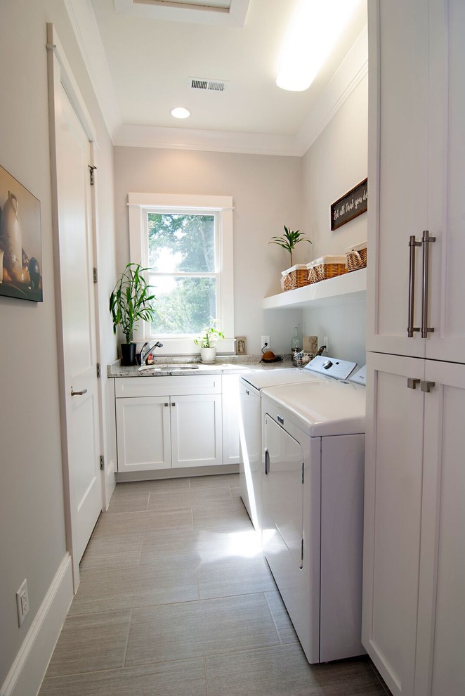 Small transitional l-shaped dedicated laundry room in Charlotte with a single-bowl sink, shaker cabinets, white cabinets, granite benchtops, grey walls, porcelain floors, a side-by-side washer and dryer and beige floor.