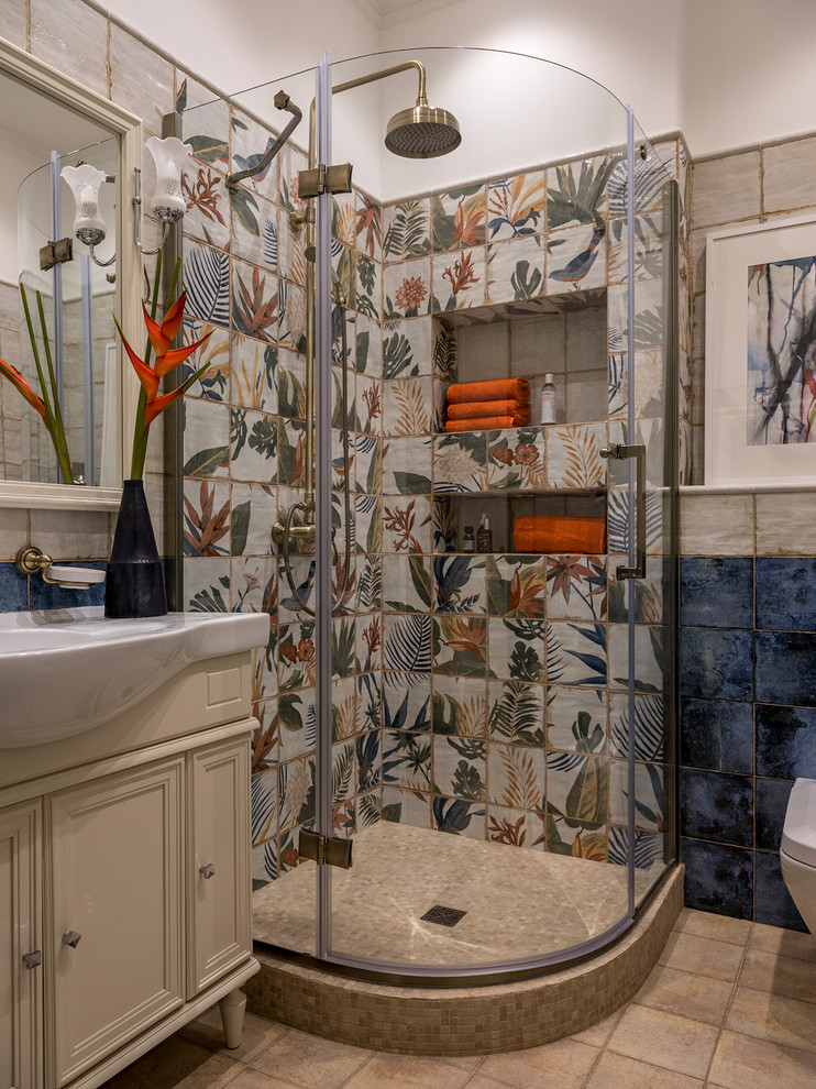 This is an example of a mid-sized transitional 3/4 bathroom in Moscow with recessed-panel cabinets, beige cabinets, a corner shower, a wall-mount toilet, blue tile, ceramic tile, beige walls, ceramic floors, a drop-in sink, marble benchtops, beige floor, a hinged shower door and white benchtops.