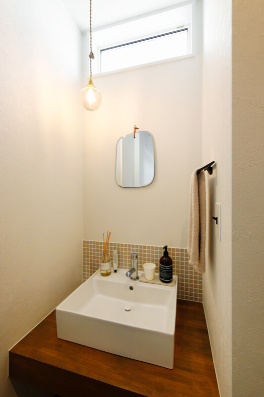 На фото: туалет среднего размера в стиле модернизм с бежевыми фасадами, бежевой плиткой, столешницей из плитки, коричневой столешницей, акцентной стеной, встроенной тумбой, потолком с обоями и обоями на стенах