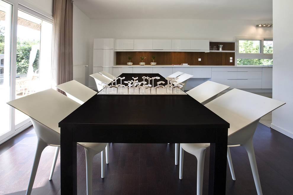 This is an example of a contemporary kitchen/dining combo in Paris with white walls.