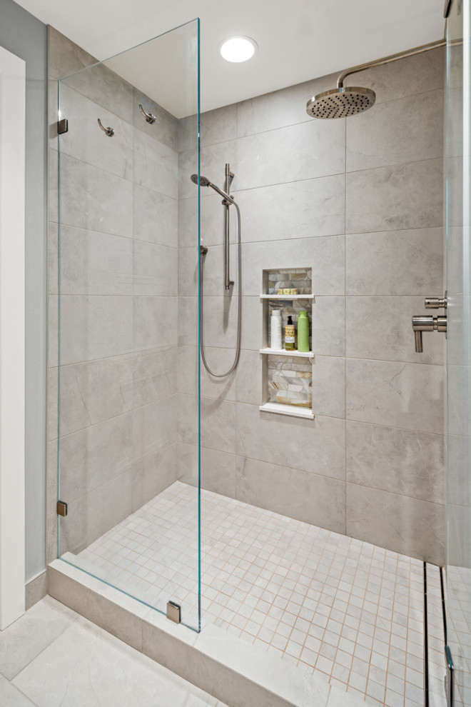 Inspiration for a mid-sized contemporary bathroom in Seattle with recessed-panel cabinets, medium wood cabinets, a freestanding tub, an alcove shower, a bidet, white tile, marble, grey walls, porcelain floors, an undermount sink, marble benchtops, beige floor, a hinged shower door, white benchtops, a niche, a single vanity, a built-in vanity, exposed beam and decorative wall panelling.