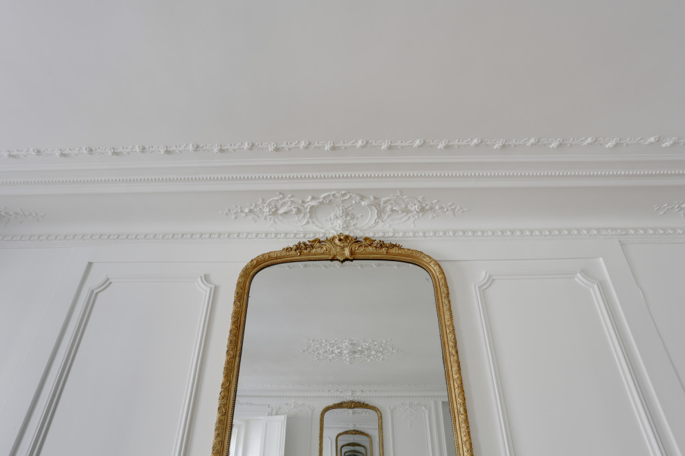 Пример оригинального дизайна: огромная изолированная гостиная комната в стиле неоклассика (современная классика) с белыми стенами, полом из линолеума, бежевым полом и панелями на стенах без камина