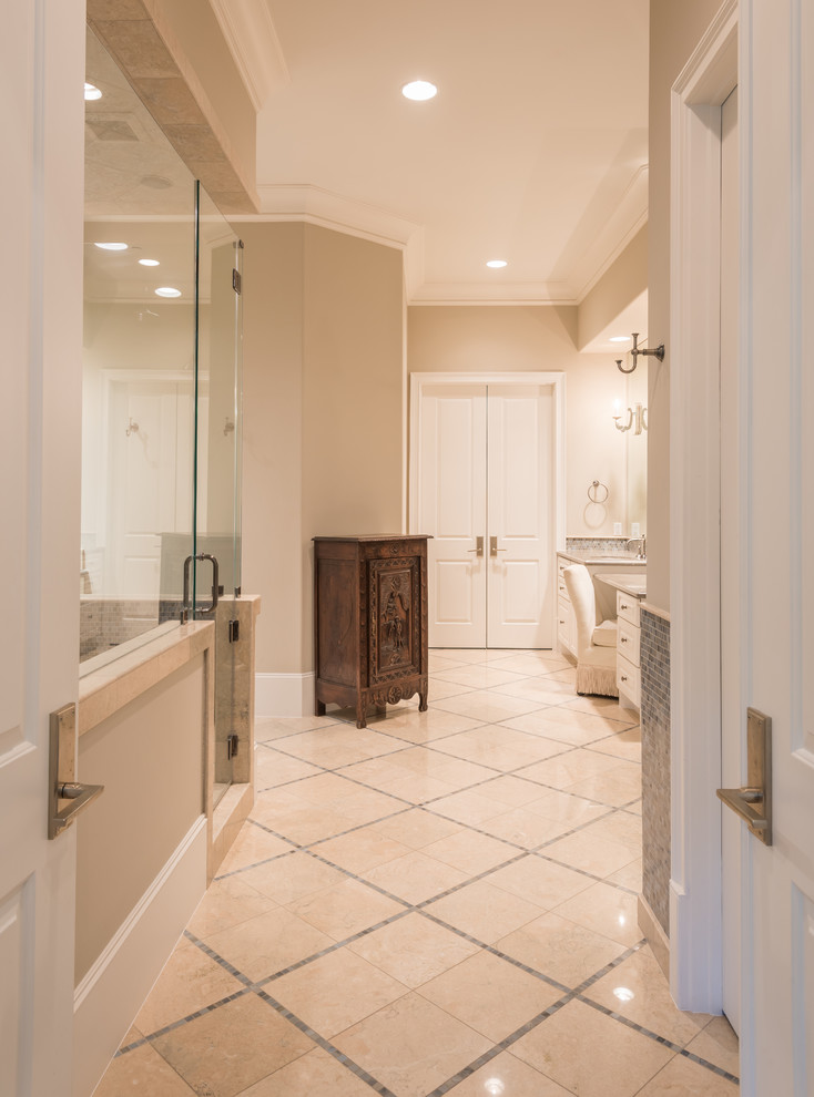 Large traditional master bathroom in Houston with raised-panel cabinets, white cabinets, a freestanding tub, a corner shower, blue tile, glass tile, beige walls, an undermount sink and marble floors.