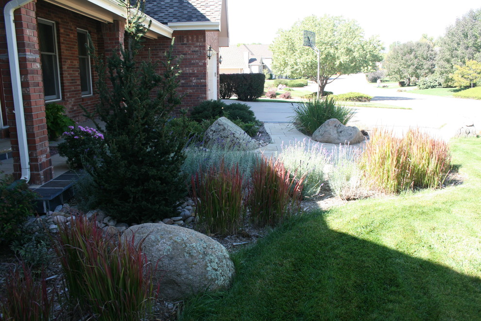 Photo of a small traditional front yard partial sun driveway in Denver with natural stone pavers.
