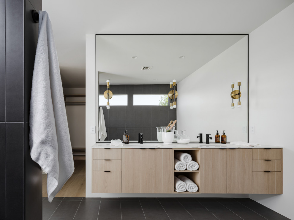 Photo of a medium sized scandi ensuite bathroom in Phoenix with flat-panel cabinets, light wood cabinets, a freestanding bath, a built-in shower, grey tiles, porcelain tiles, white walls, porcelain flooring, a built-in sink, engineered stone worktops, grey floors, an open shower, white worktops, an enclosed toilet, double sinks and a floating vanity unit.