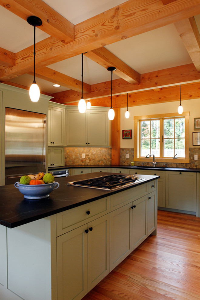 This is an example of a country kitchen in Philadelphia with stainless steel appliances and green cabinets.