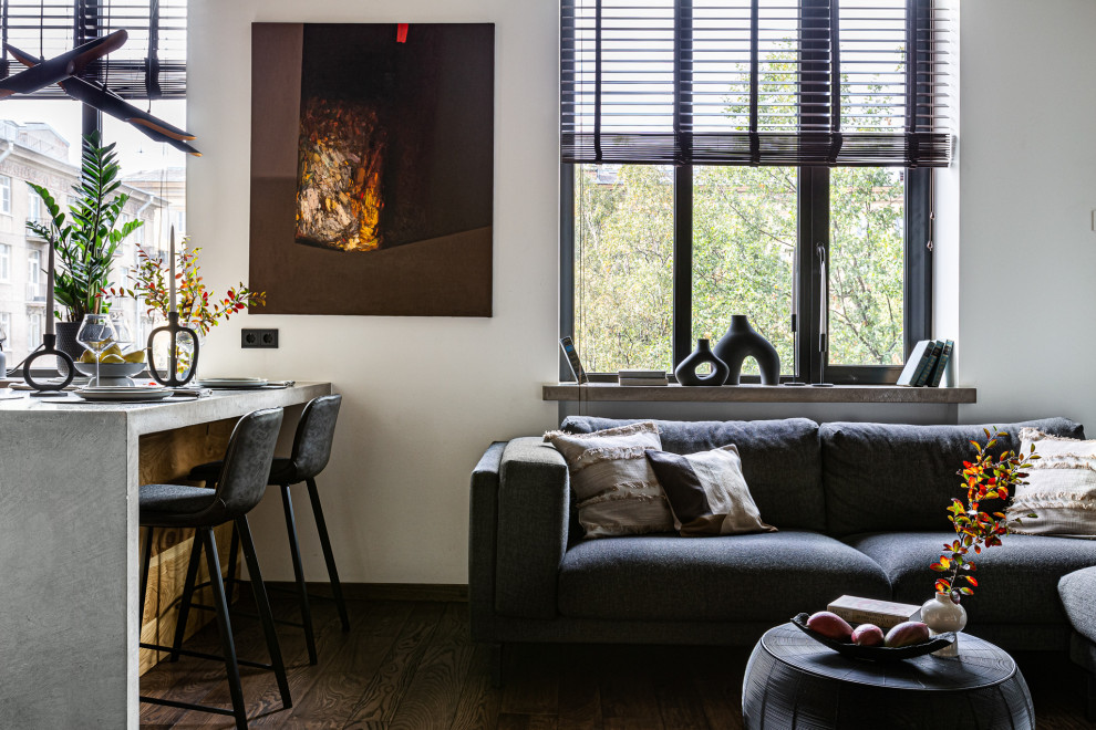 Пример оригинального дизайна: открытая, серо-белая гостиная комната среднего размера в стиле лофт с с книжными шкафами и полками, серыми стенами, полом из винила, мультимедийным центром, коричневым полом и деревянным потолком