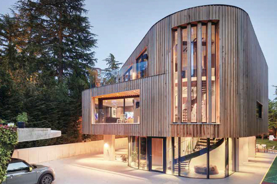 Inspiration pour une grande façade de maison design en bois et planches et couvre-joints à deux étages et plus avec un toit plat et un toit en métal.