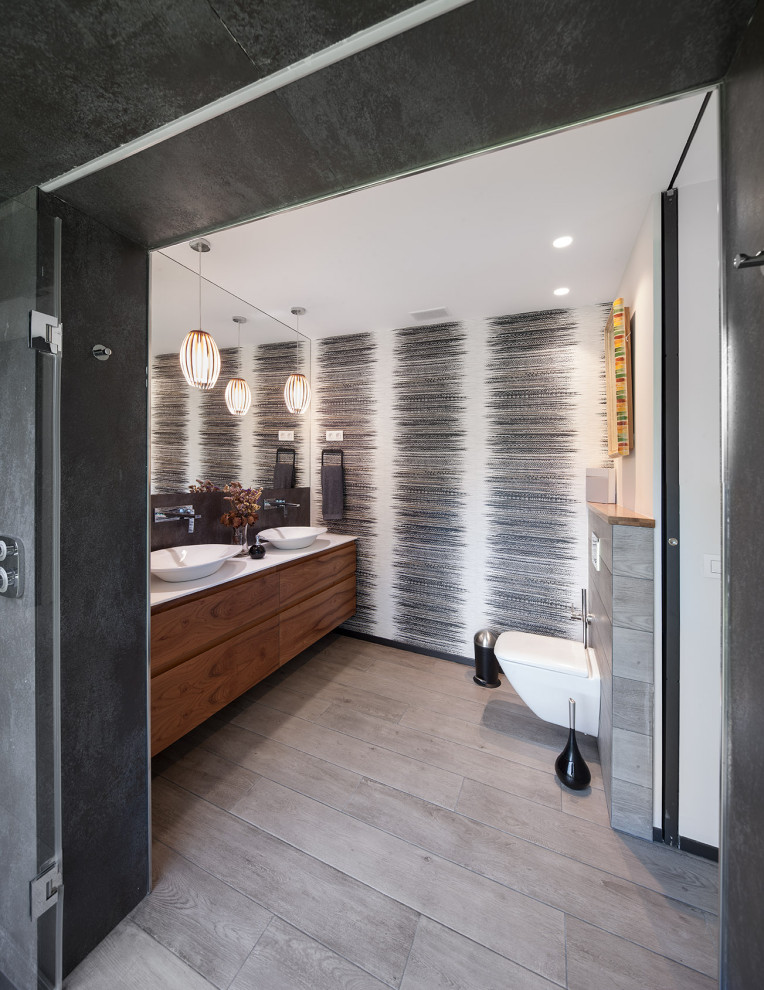 Contemporary bathroom in Other with flat-panel cabinets, dark wood cabinets, multi-coloured walls, a vessel sink, grey floor, white benchtops, a double vanity, a floating vanity and wallpaper.