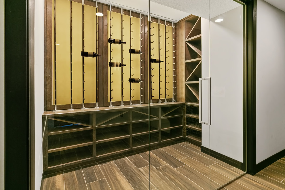 Photo of a mid-sized transitional wine cellar in Minneapolis with porcelain floors, display racks and brown floor.