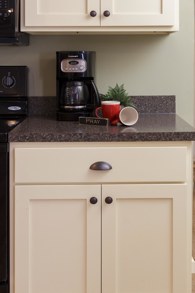 Example of a mid-sized transitional u-shaped light wood floor and beige floor enclosed kitchen design with a double-bowl sink, shaker cabinets, white cabinets, granite countertops, black appliances, no island and gray countertops