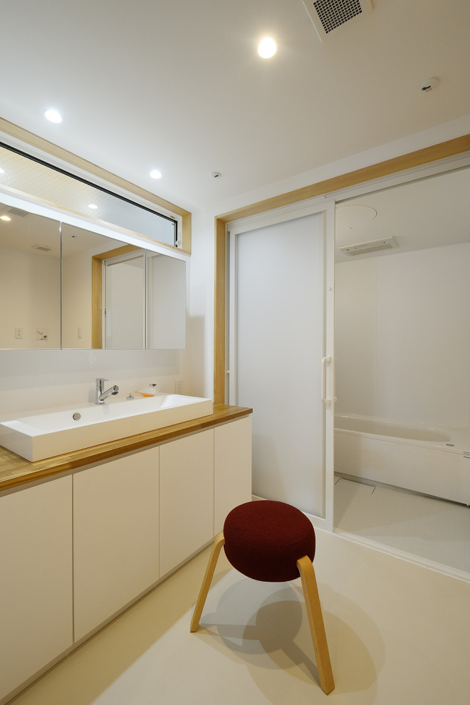 На фото: туалет в стиле модернизм с белыми стенами, полом из винила, серым полом, встроенной тумбой, потолком с обоями и обоями на стенах