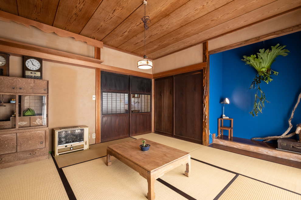 This is an example of an asian family room in Other with brown walls, tatami floors and brown floor.