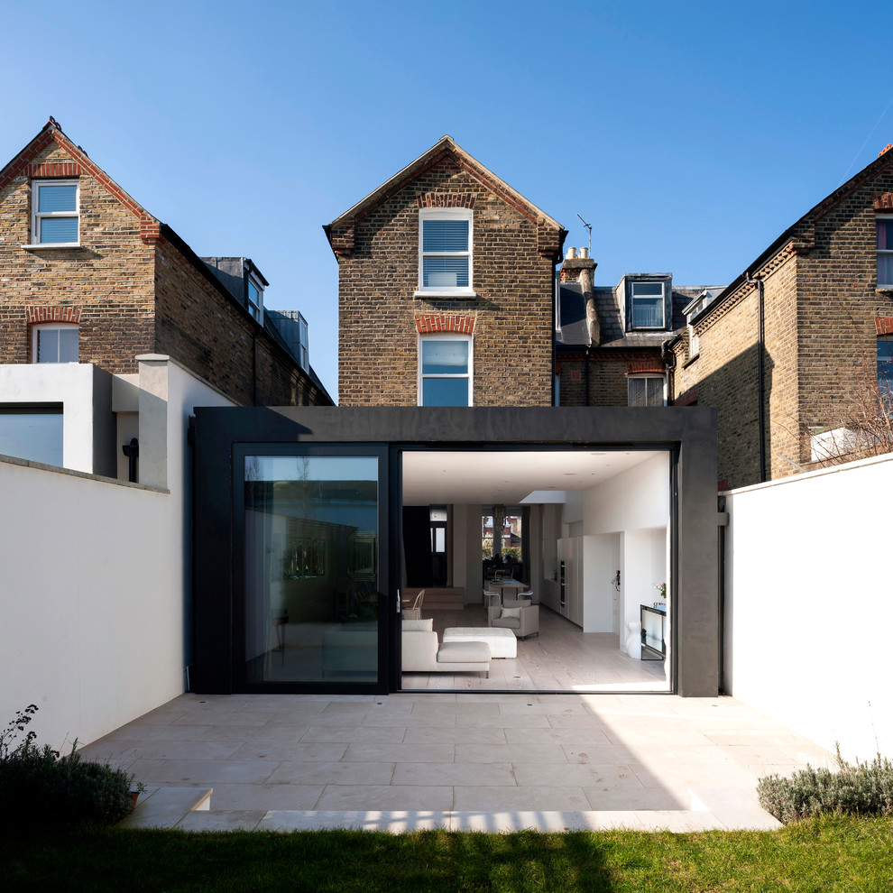 Contemporary three-storey exterior in London with mixed siding.