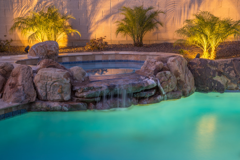 Mid-sized tuscan backyard tile and custom-shaped hot tub photo in Phoenix