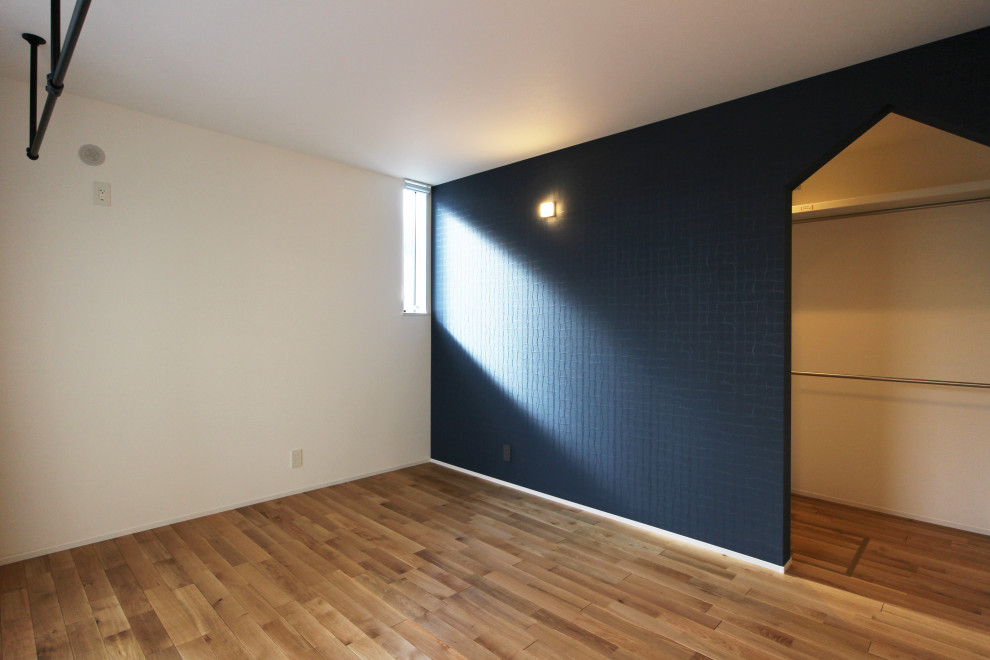 Mittelgroßes Modernes Hauptschlafzimmer ohne Kamin mit blauer Wandfarbe, braunem Holzboden, beigem Boden, Tapetendecke und Tapetenwänden in Sonstige