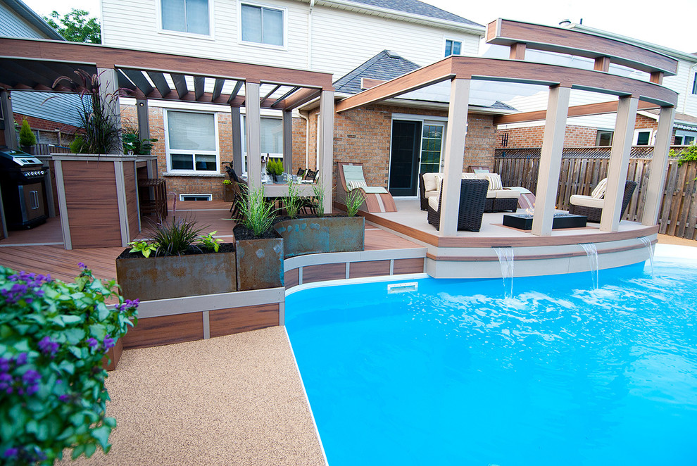 This is an example of a mid-sized transitional backyard deck in Toronto with a water feature and an awning.