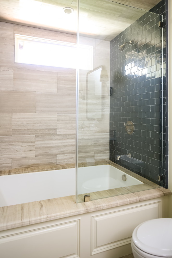 Photo of a mediterranean bathroom in Los Angeles with recessed-panel cabinets, medium wood cabinets, an undermount tub, a shower/bathtub combo, white walls, porcelain floors, an undermount sink, marble benchtops, grey floor, an open shower and grey benchtops.