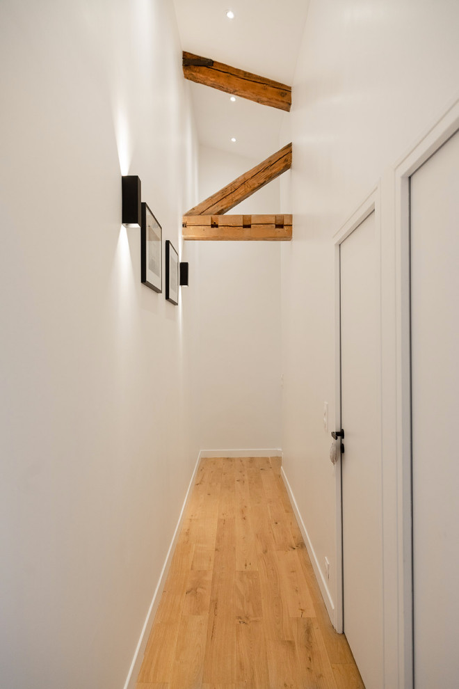 Inspiration för små moderna hallar, med vita väggar, ljust trägolv och beiget golv