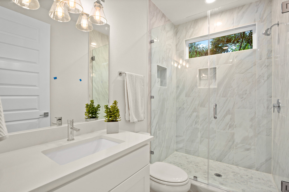 This is an example of a rural shower room bathroom in Austin with white cabinets, an alcove shower, white tiles, a hinged door, white worktops, a single sink and a built in vanity unit.