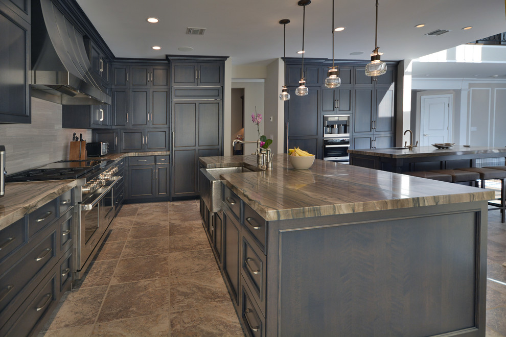 Inspiration for a large transitional l-shaped travertine floor eat-in kitchen remodel in New York with a farmhouse sink, raised-panel cabinets, dark wood cabinets, quartzite countertops, gray backsplash, stainless steel appliances and two islands