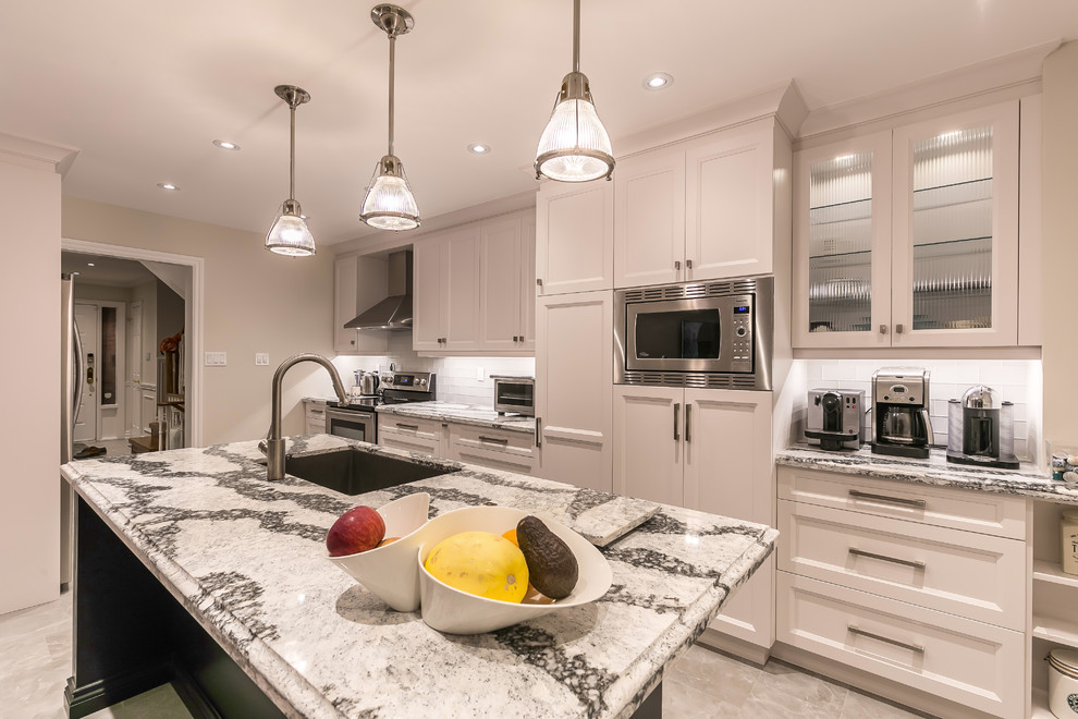 Enclosed kitchen - large transitional gray floor enclosed kitchen idea in Toronto with an undermount sink, recessed-panel cabinets, white cabinets, stainless steel appliances, an island, quartz countertops, white backsplash and ceramic backsplash