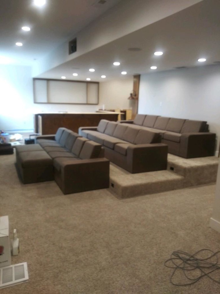 Modern home theatre in Indianapolis with carpet and beige floor.