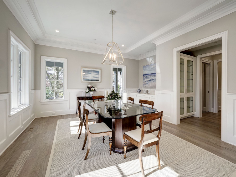 This is an example of a large transitional separate dining room in DC Metro with grey walls, medium hardwood floors and beige floor.