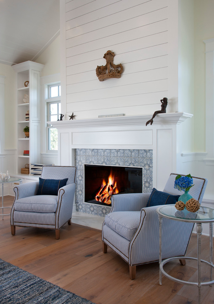 Inspiration for a mid-sized beach style open concept living room in San Diego with white walls, light hardwood floors, a standard fireplace, a tile fireplace surround and grey floor.
