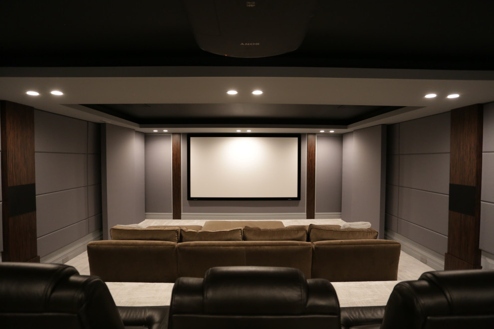 Idee per un grande home theatre contemporaneo chiuso con pareti grigie, moquette, schermo di proiezione e pavimento beige