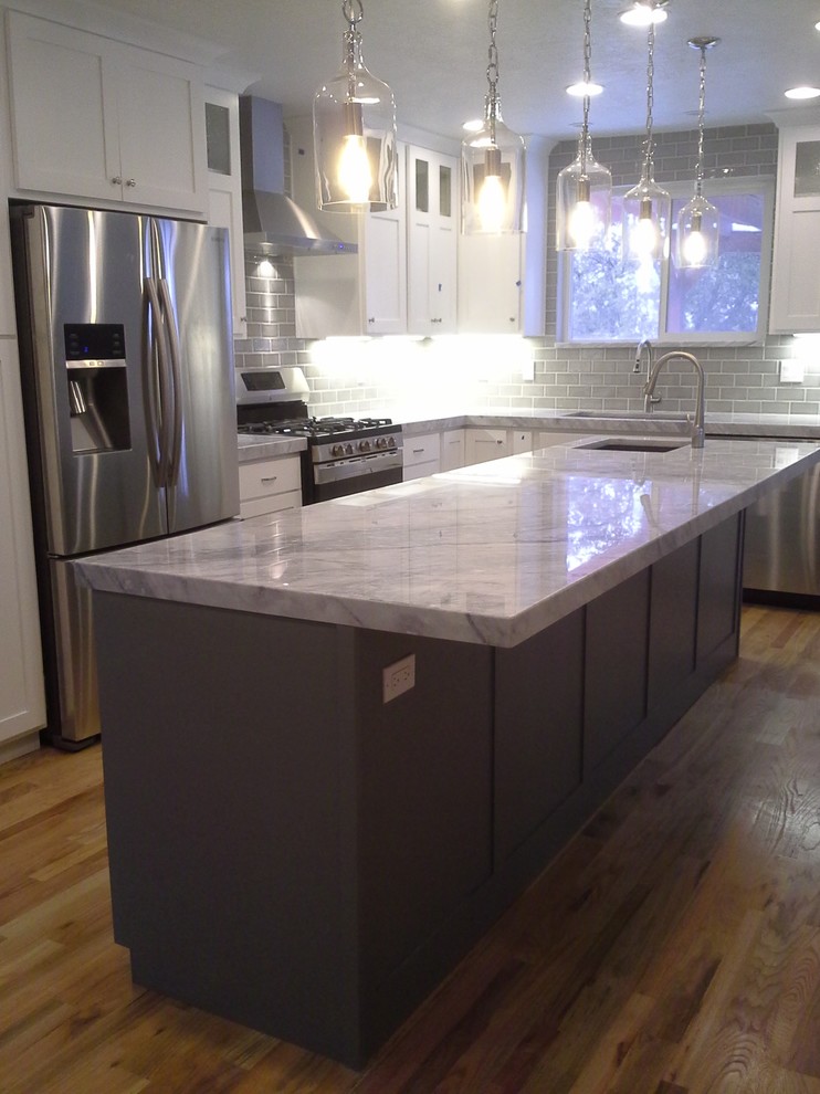 Inspiration for a mid-sized arts and crafts l-shaped eat-in kitchen in Salt Lake City with an undermount sink, shaker cabinets, white cabinets, quartzite benchtops, grey splashback, subway tile splashback, stainless steel appliances, light hardwood floors and with island.