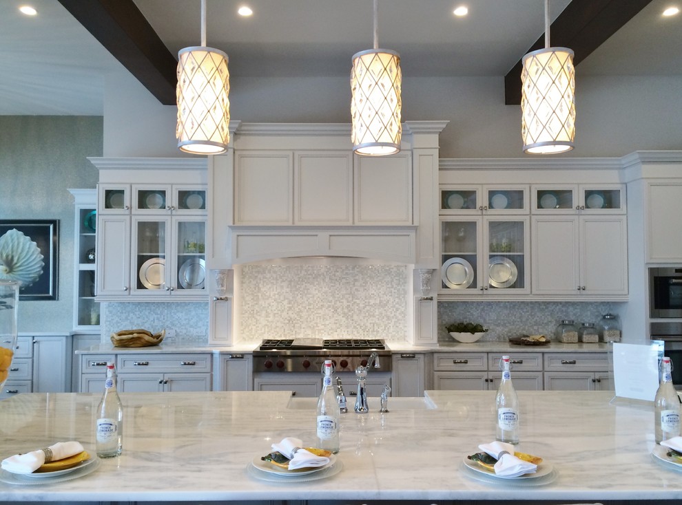 Eat-in kitchen - large transitional galley dark wood floor eat-in kitchen idea in Tampa with a farmhouse sink, recessed-panel cabinets, white cabinets, marble countertops, white backsplash, glass tile backsplash, paneled appliances and an island