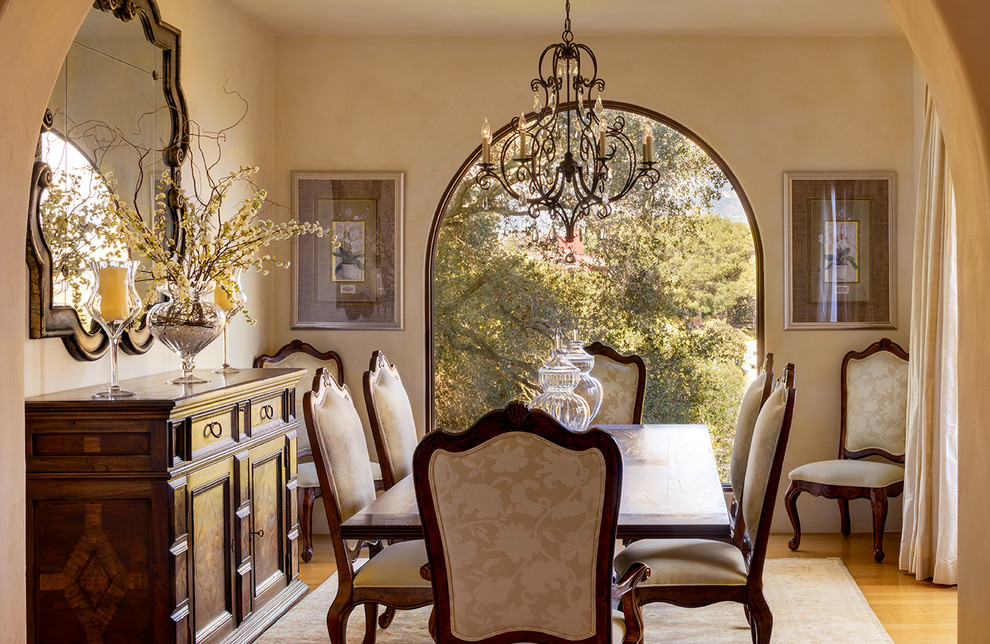 Mid-sized mediterranean dining room in Santa Barbara with beige walls and medium hardwood floors.