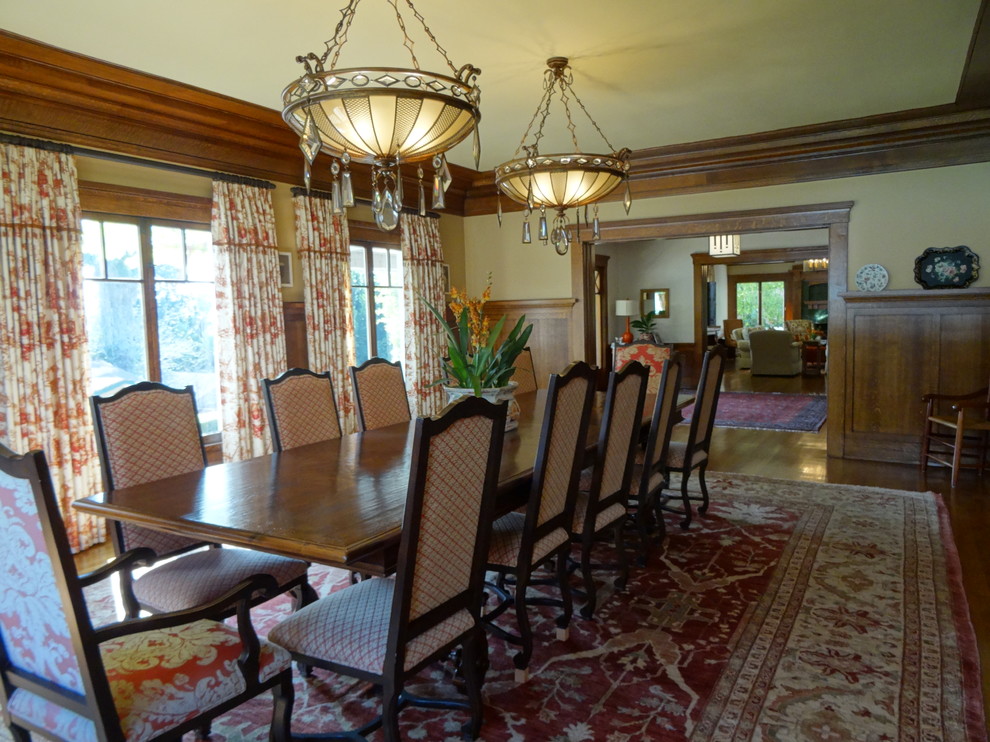 Photo of a large arts and crafts dining room in Los Angeles with yellow walls, dark hardwood floors and no fireplace.