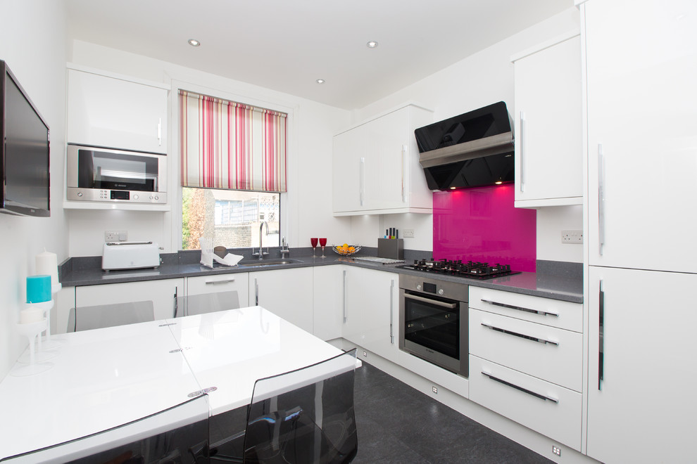 Inspiration for a small contemporary l-shaped eat-in kitchen in London with an undermount sink, flat-panel cabinets, white cabinets, pink splashback, quartzite benchtops, glass sheet splashback, stainless steel appliances and grey floor.