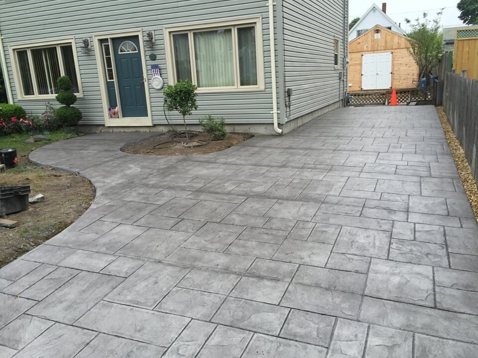 Inspiration for a mid-sized traditional front yard full sun driveway in Boston with concrete pavers.