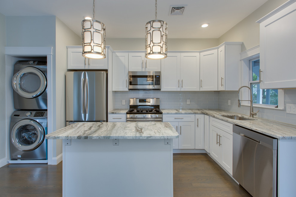 Mid-sized transitional l-shaped dark wood floor and brown floor enclosed kitchen photo in Boston with an undermount sink, shaker cabinets, white cabinets, marble countertops, gray backsplash, subway tile backsplash, stainless steel appliances, an island and white countertops