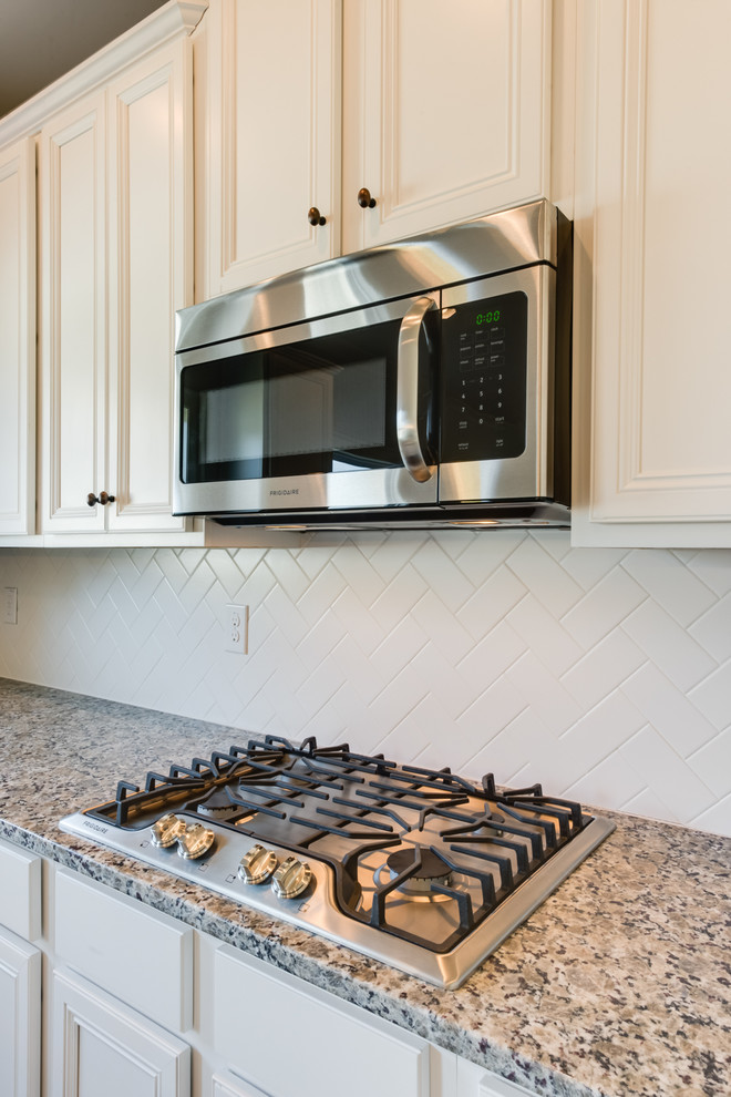 Eat-in kitchen - large transitional u-shaped dark wood floor and brown floor eat-in kitchen idea with an undermount sink, recessed-panel cabinets, white cabinets, granite countertops, white backsplash, subway tile backsplash, stainless steel appliances and an island