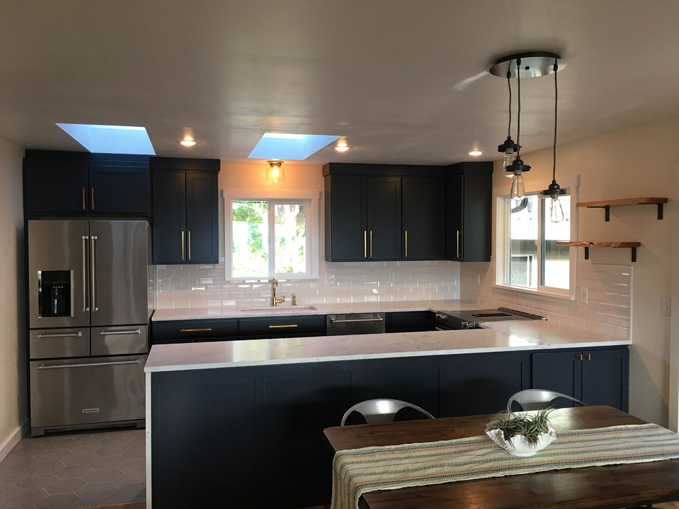 Inspiration for a mid-sized transitional u-shaped enclosed kitchen remodel in Seattle with shaker cabinets, black cabinets, white backsplash, subway tile backsplash, stainless steel appliances and a peninsula