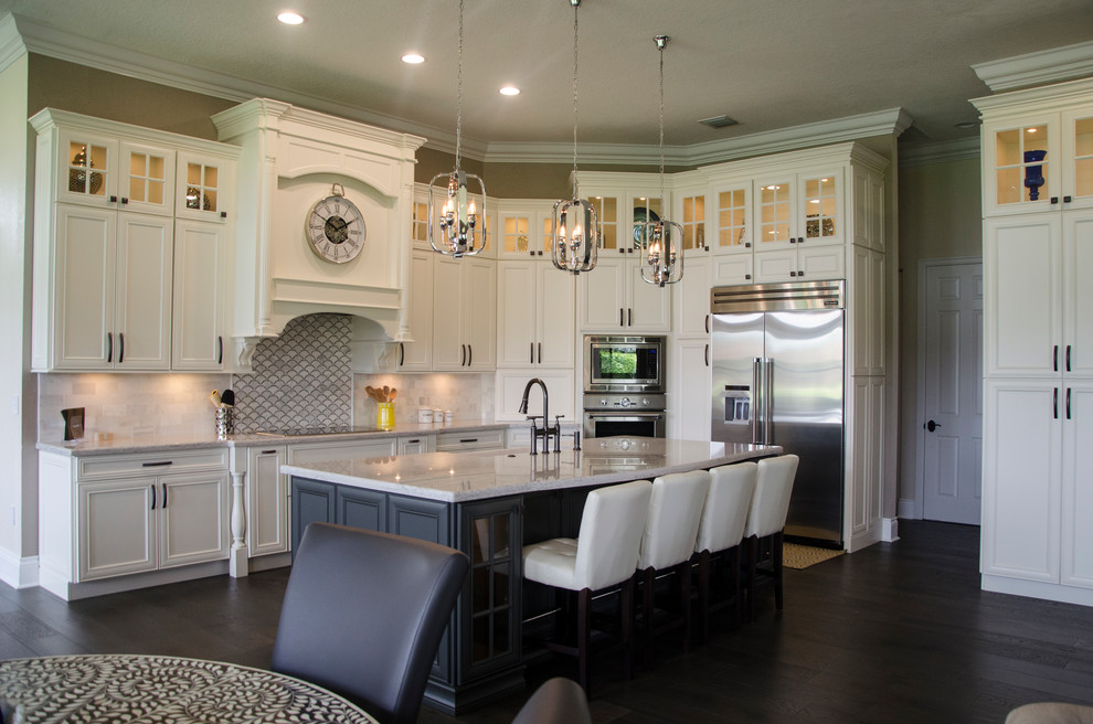 Example of a huge transitional porcelain tile kitchen design in Miami with a farmhouse sink, recessed-panel cabinets, white cabinets, quartz countertops, gray backsplash, stainless steel appliances and an island