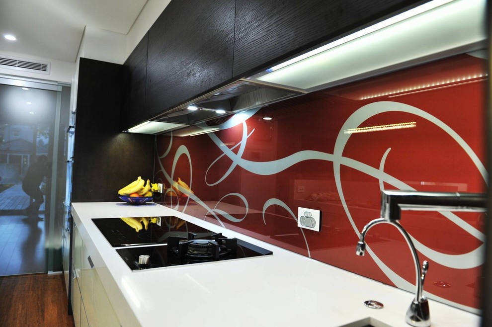 Design ideas for a modern kitchen in Sydney with glass sheet splashback.
